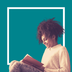 a person sits reading a book in front of a blue background and white square outline